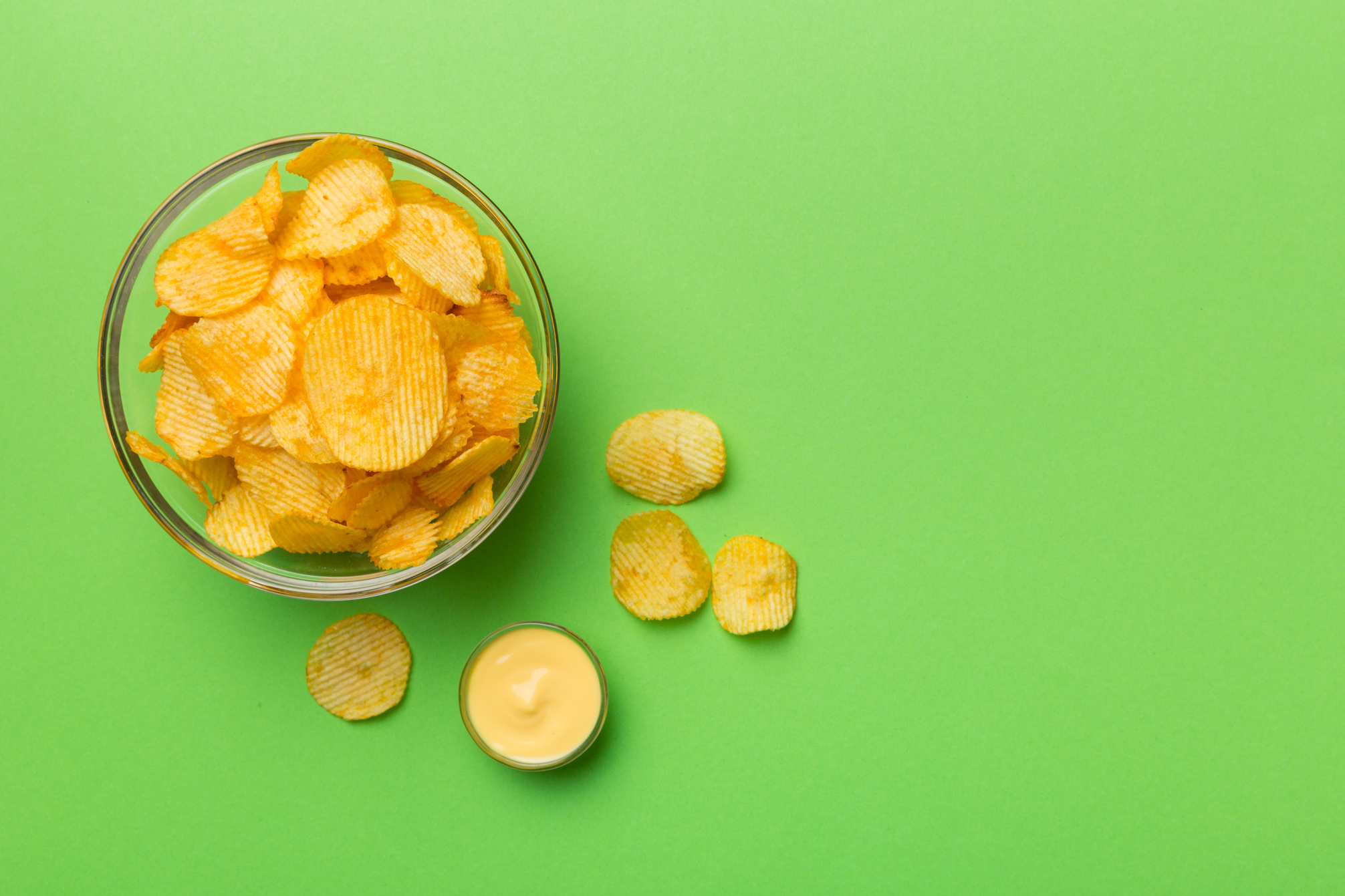 Top view chips with sause in bowl on colored background, top view with copy space